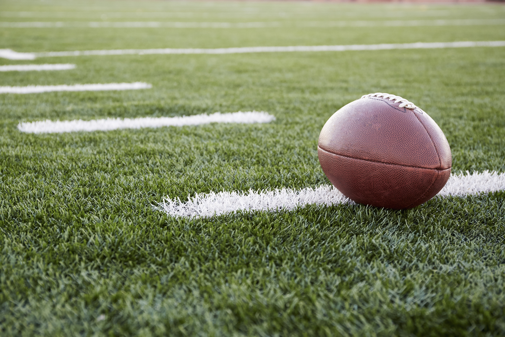 A football sits on a football field.