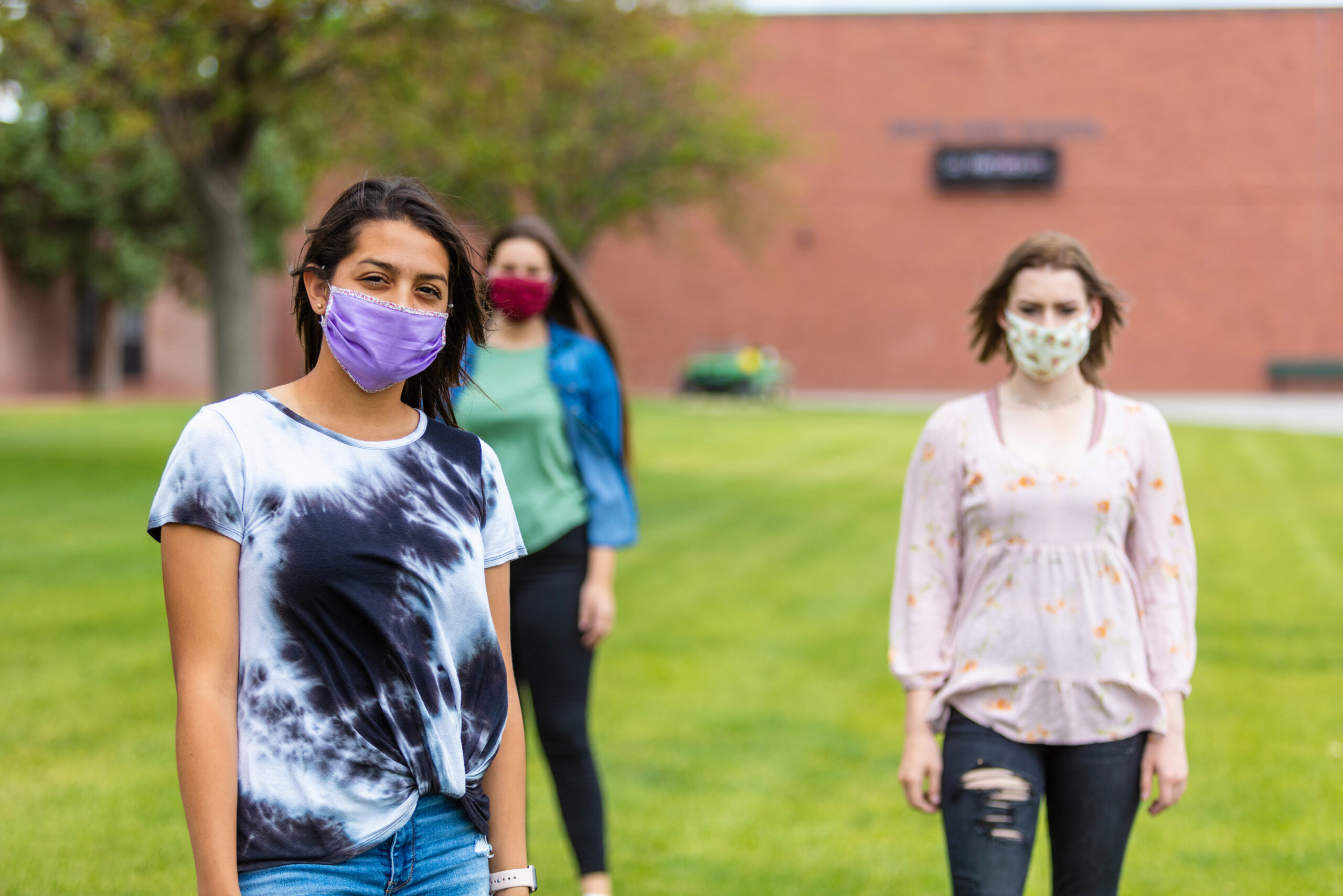 Group of Generation Z Multi-Ethnic Female Friends Wearing Face Masks and Social Distancing