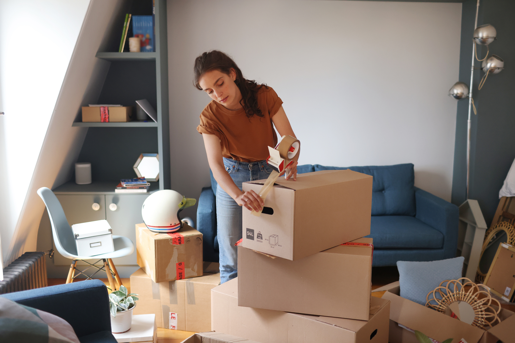 A college-aged female student packing up boxes as she moves out of her apartment.