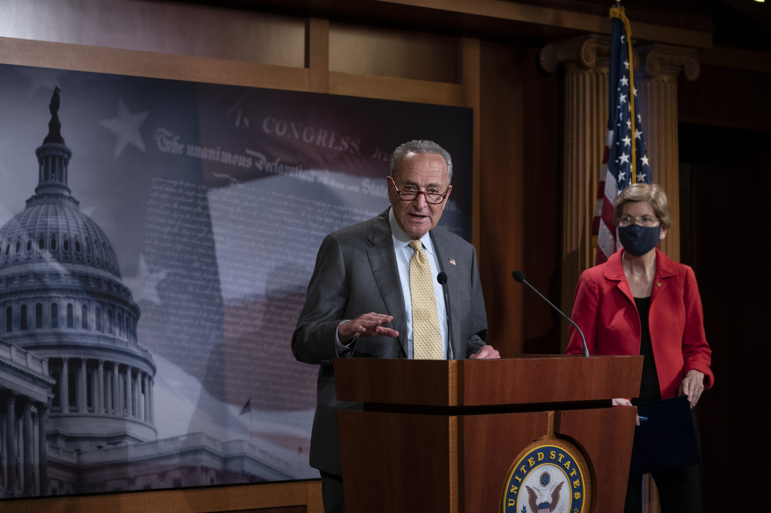 Senate Minority Leader Chuck Schumer (D-NY) speaks as Sen. Elizabeth Warren (D-MA) looks on during a news conference concerning the extension of eviction protections in the next coronavirus bill, at the U.S. Capitol