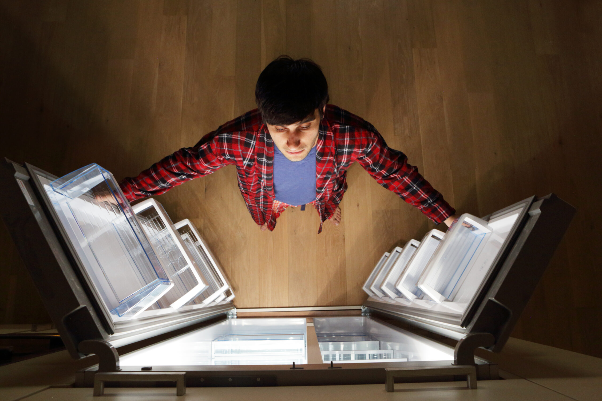 Man looking into empty fridge at night