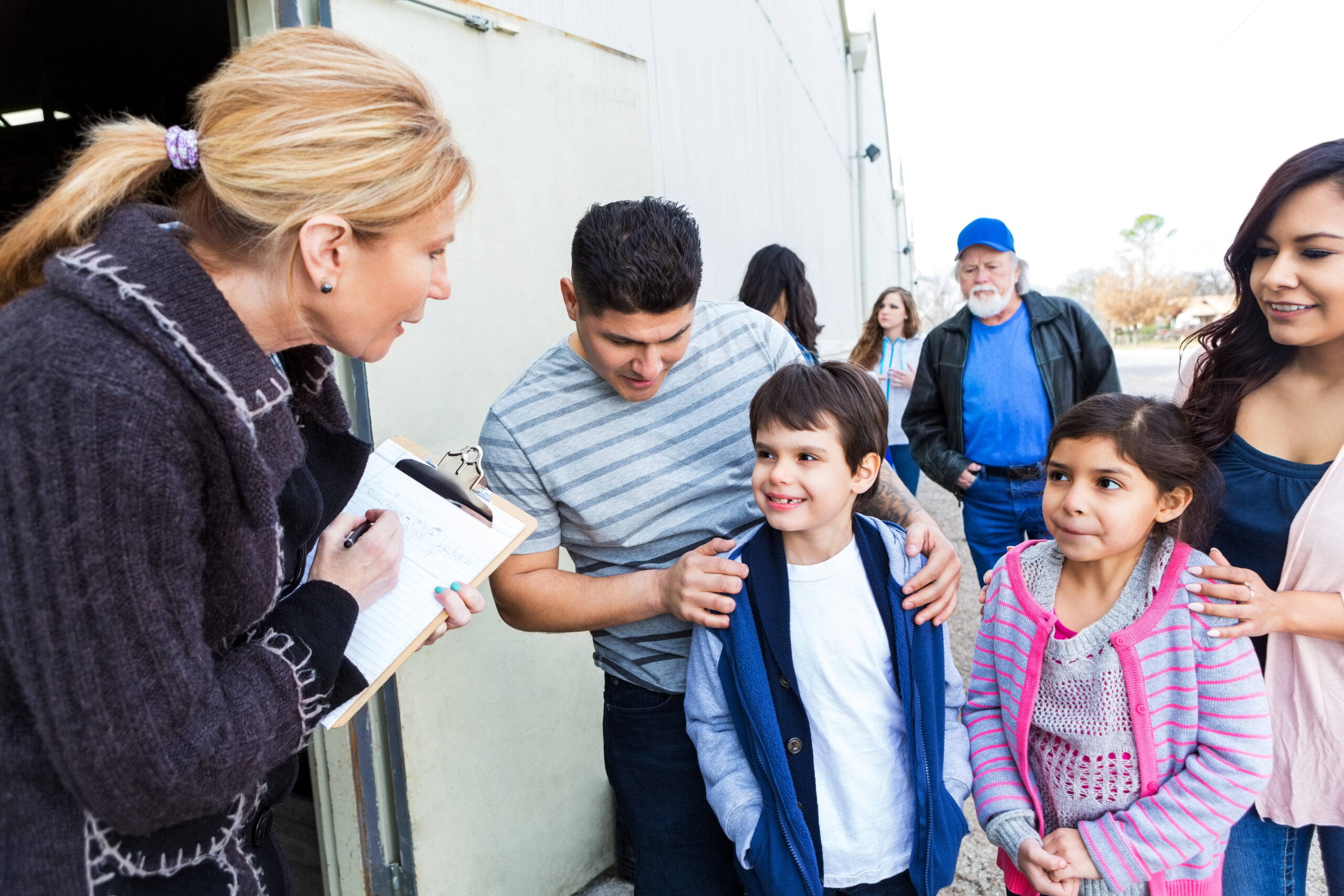 Young family signing up to volunteer at community charity