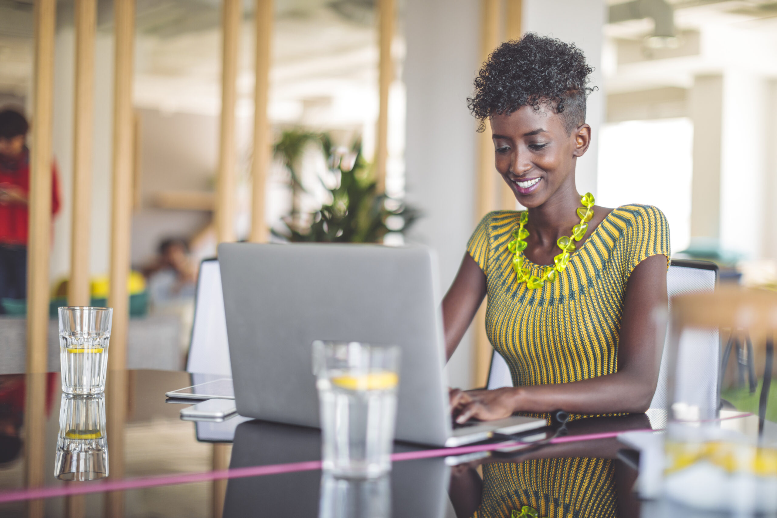 Portrait of a confident businesswoman typing on a laptop while sitting at a table