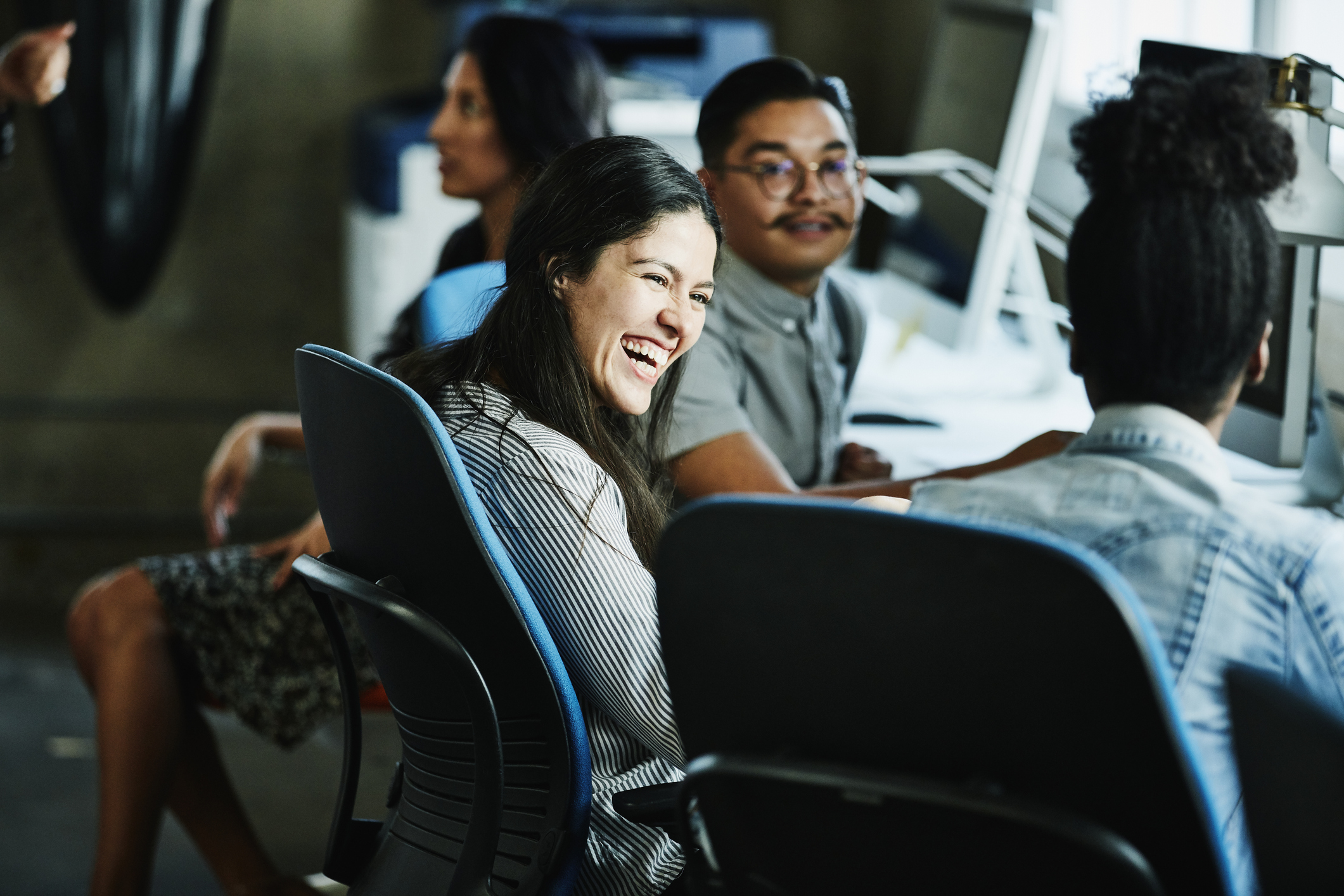 Businesswoman laughing with coworkers while working in design studio