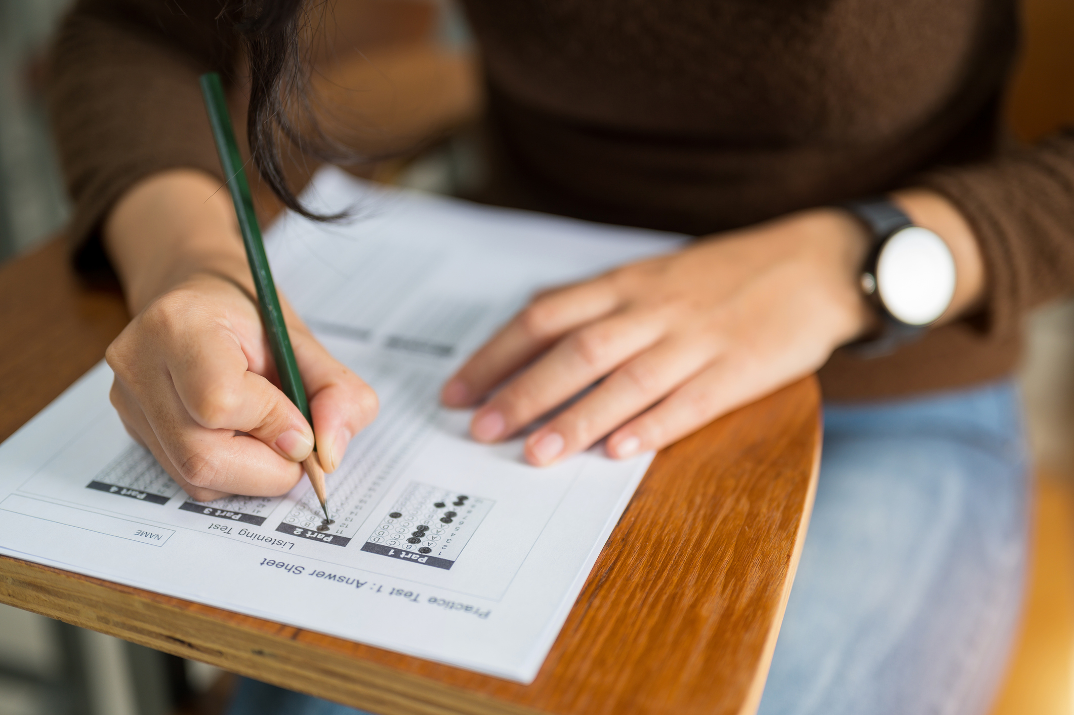 High school student sitting at a classroom desk taking the ACT examination.