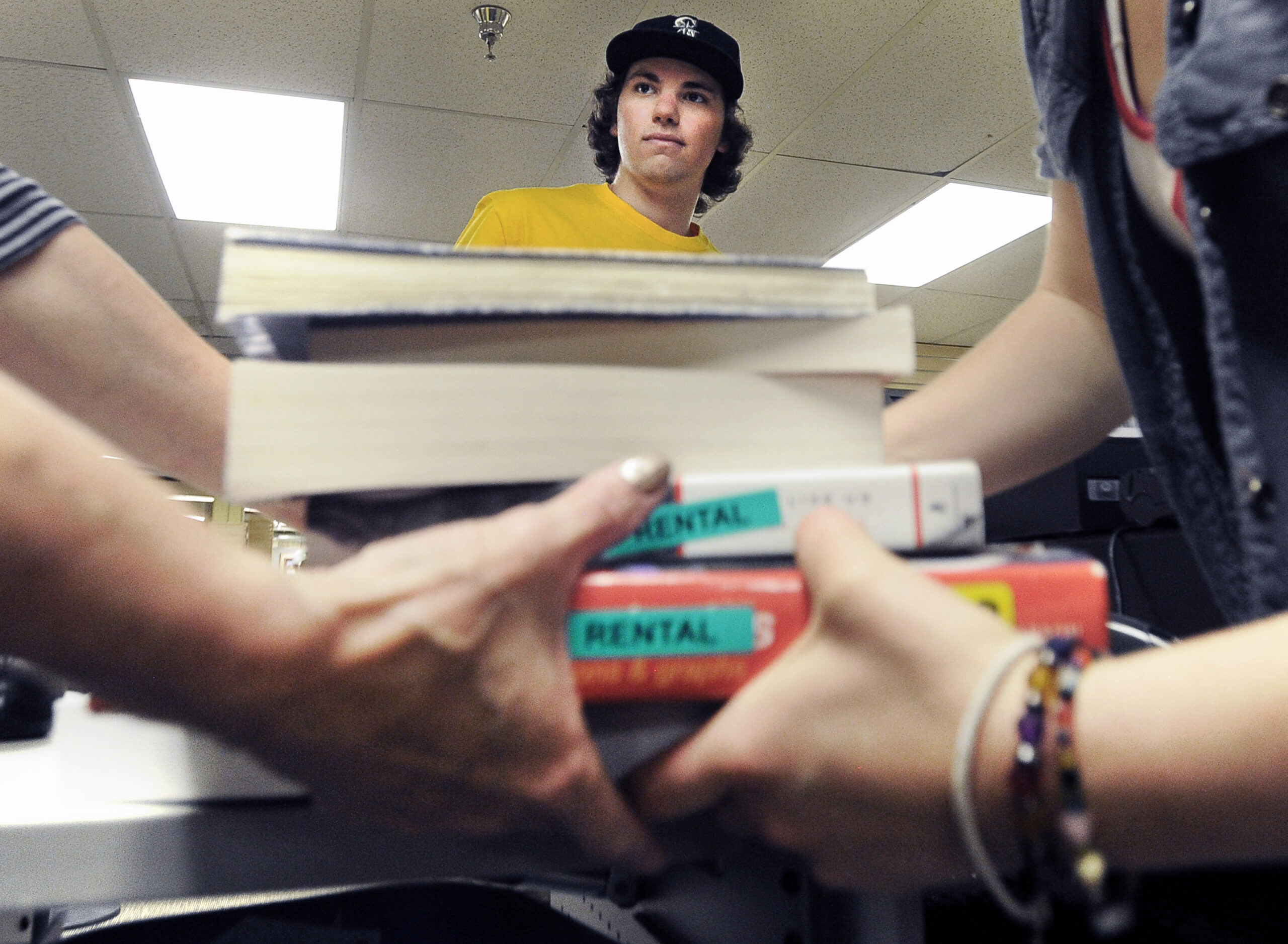 University of Colorado sophomore Evan Michalec watches as employees Kerrie Summerhays, left, and Justice Cook carry away his textbooks after selling them back to the CU bookstore inside