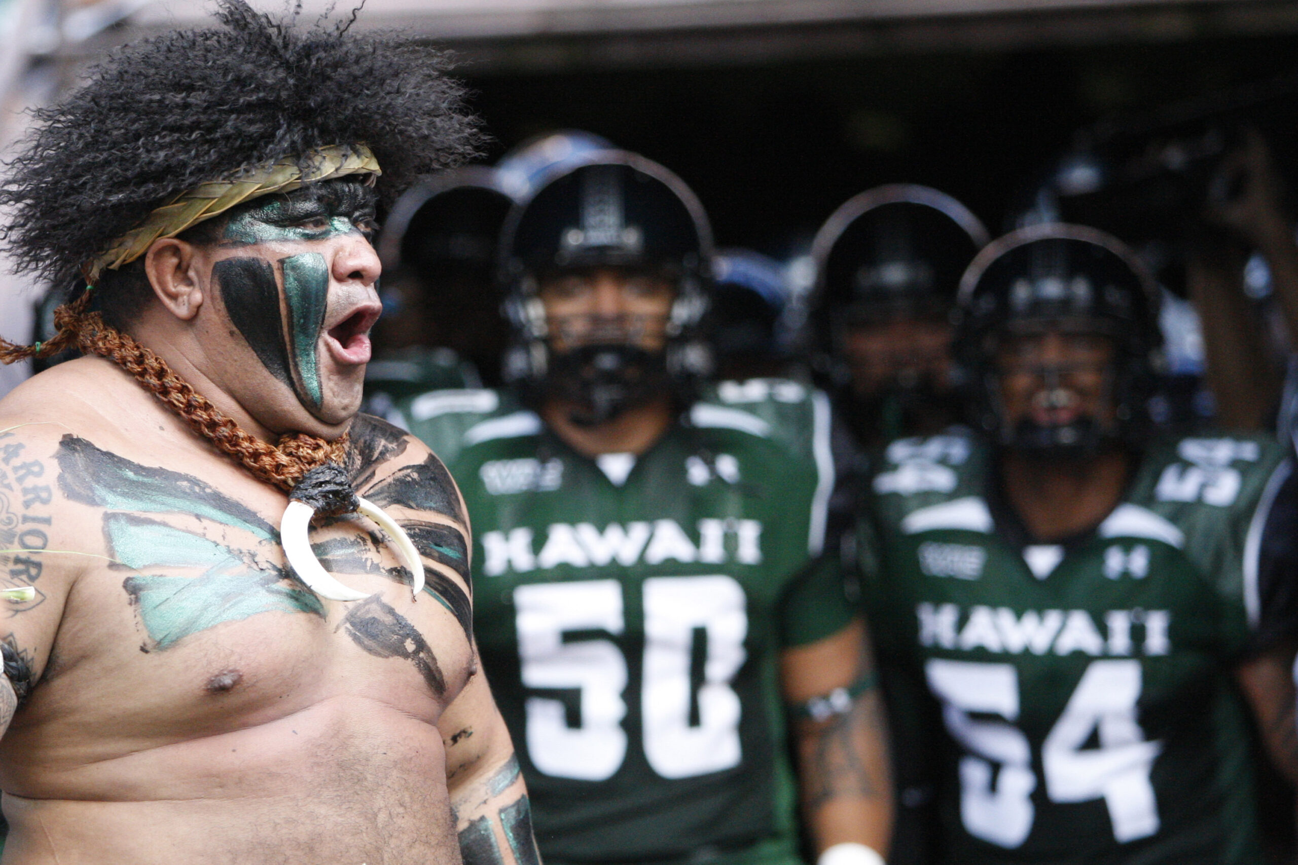 the University of Hawaii Mascot cheers as the University of Hawaii Warriors prepare to take the field in their season opener