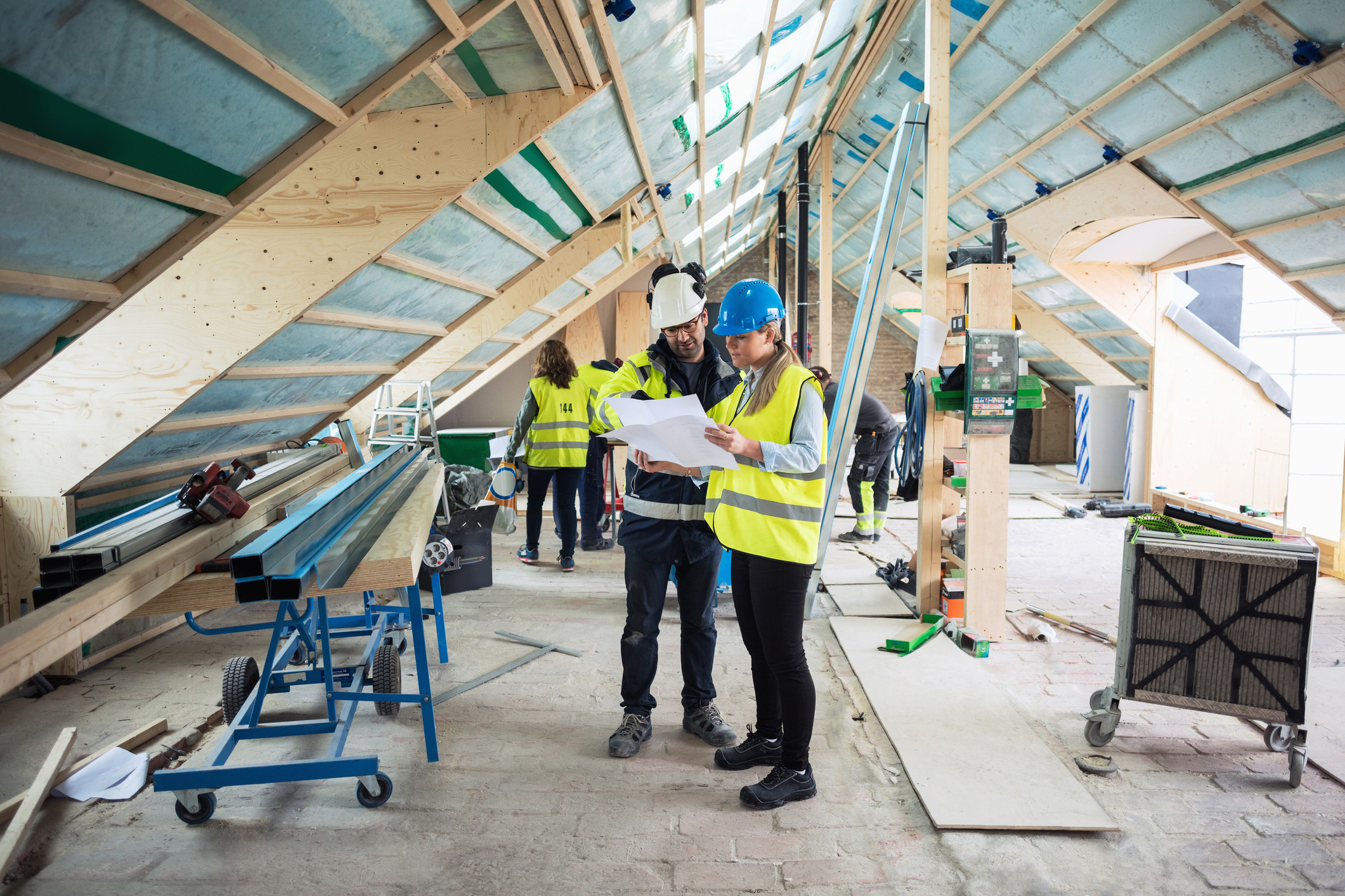 Two construction managers talking while working at an active construction site.