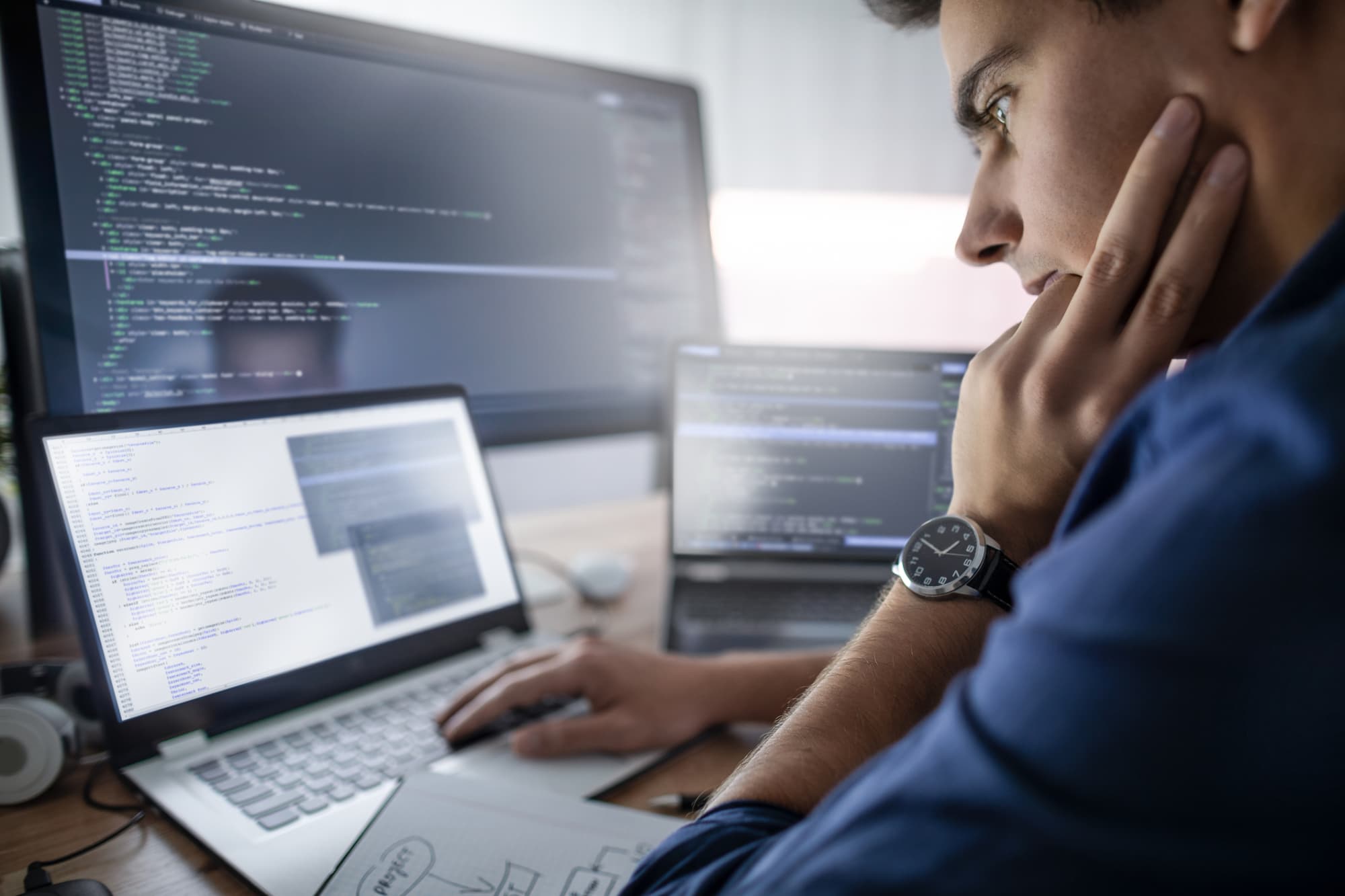 Web developer coding on his work laptop.