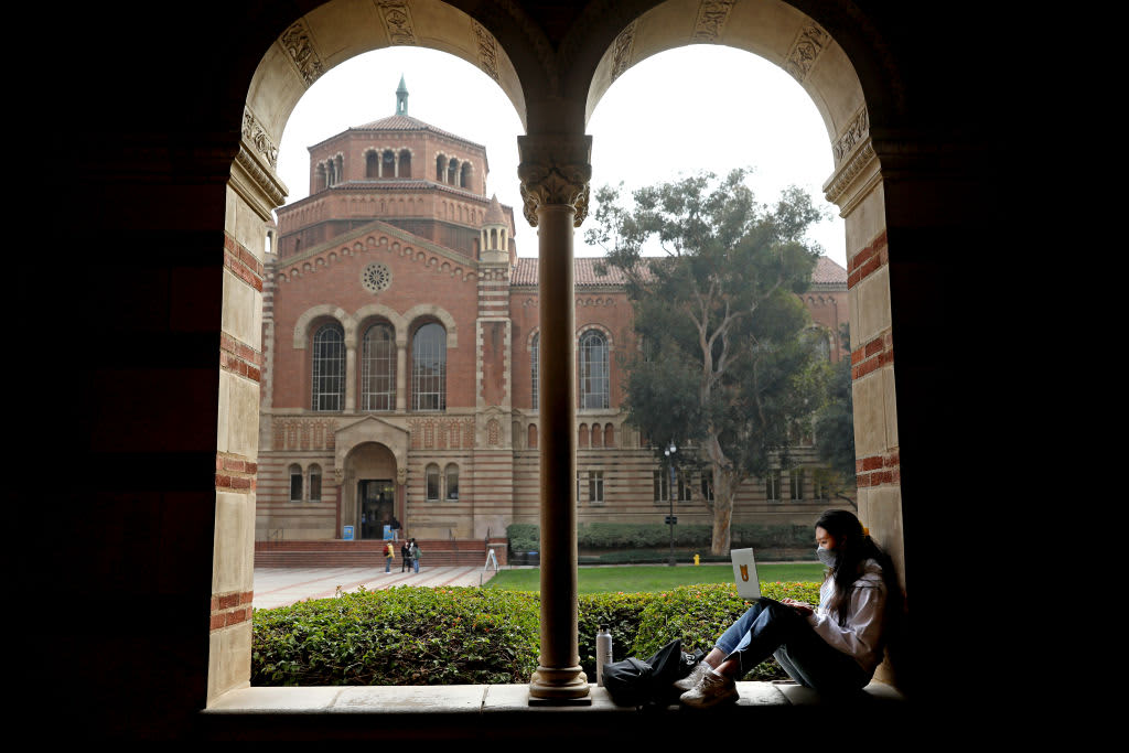 A student studying on the UCLA campus grounds in Los Angeles, California.