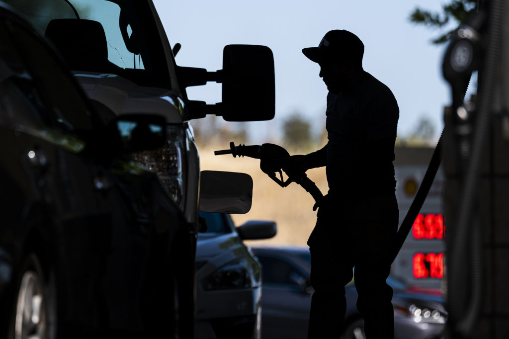 A customer holds a fuel nozzle at a Shell gas station in Hercules, California. Community colleges across the US are shifting to limited remote learning and tapping COVID-19 relief funds to ensure students can get to class in the wake of rising gas costs.