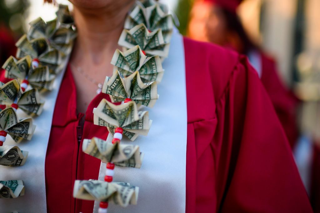 A graduating student wears a money lei, a necklace made of US dollar bills, at the Pasadena City College graduation ceremony, June 14, 2019, in Pasadena, California.