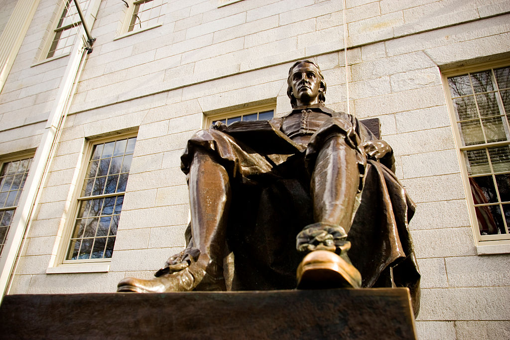 The John Harvard statue on the Harvard University campus in Cambridge. Massachusetts.