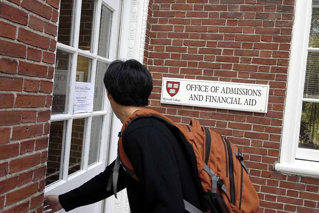 CAMBRIDGE, MA - SEPTEMBER 12: Freshman Winston Yan enters the Admissions Building at Harvard University September 12, 2006 in Cambridge, Massachusetts. Harvard is eliminating early admissions beginning next year because of criticism that it favors wealthier students and hinders those seeking financial aid since the deadlines for aid are much later.