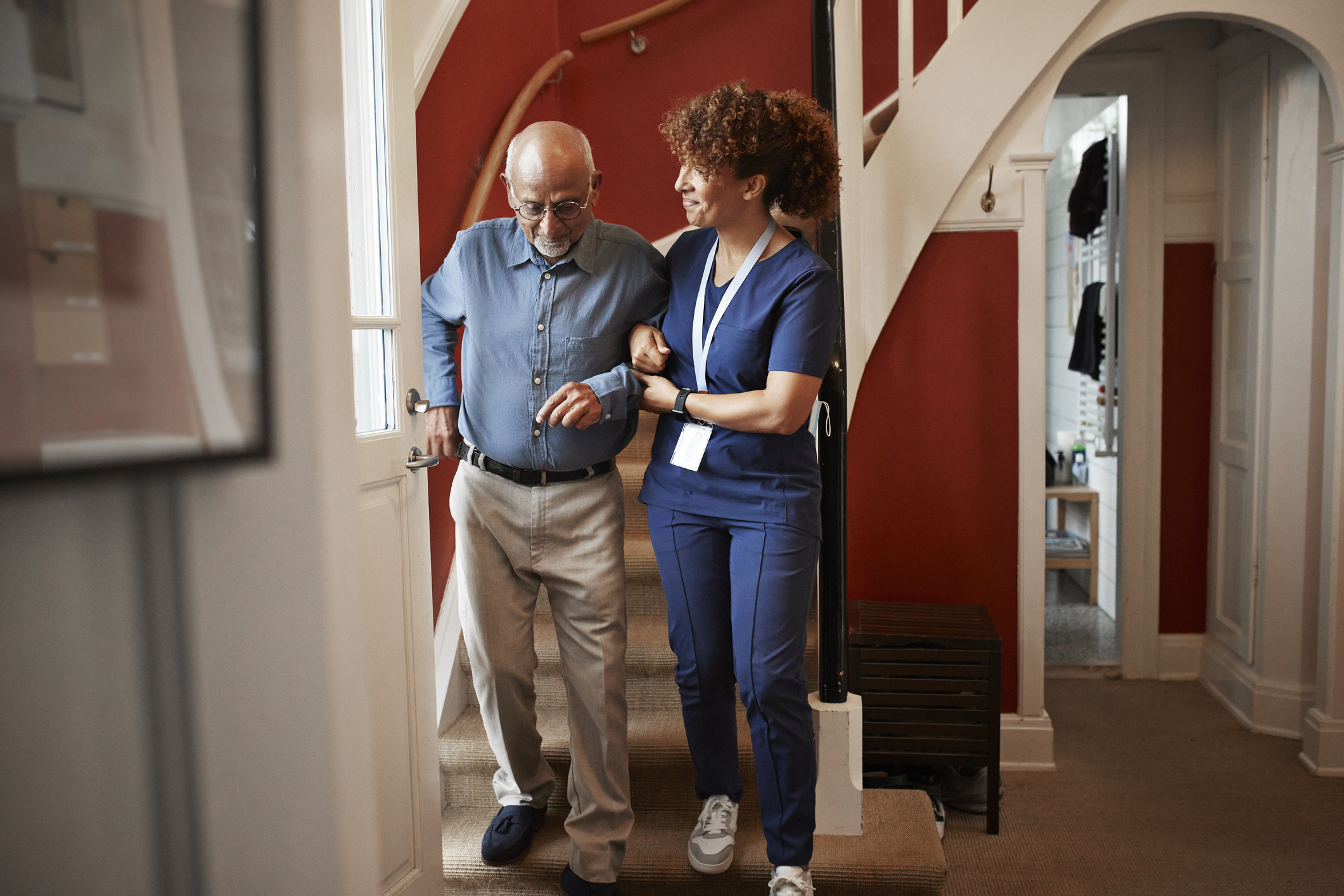 Nurse walking with senior man on steps