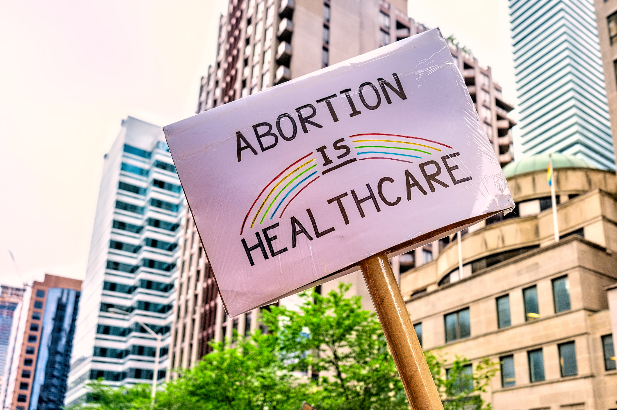 Low angle view of sign in Pride Parade. The sign says "Abortion is Healthcare"