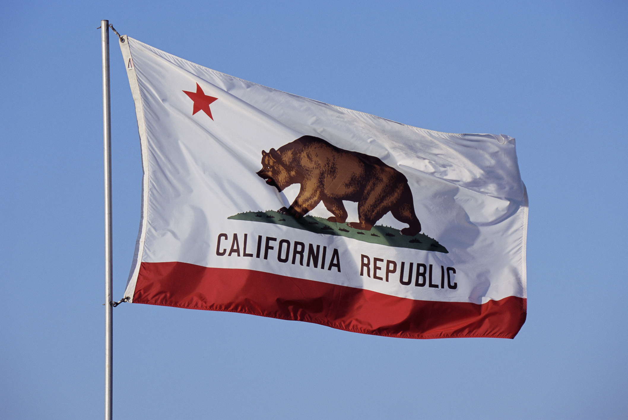 California State Flag flying outside against a clear blue sky