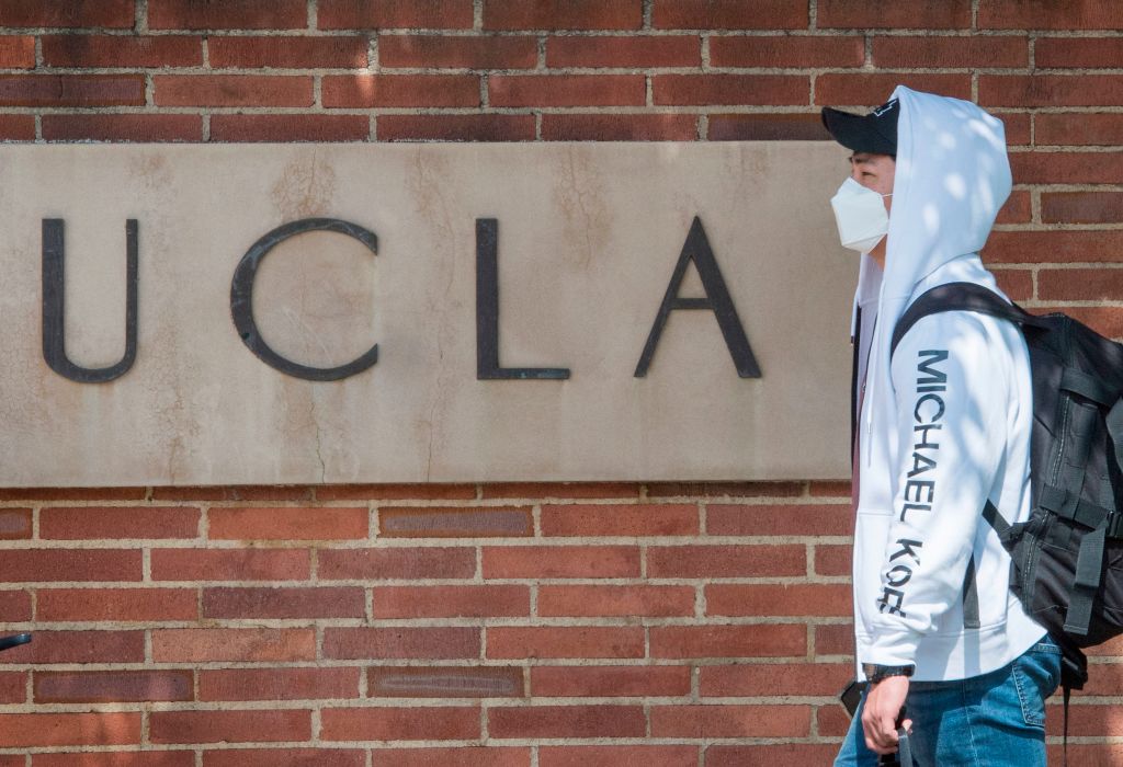 A student wearing a face mask walks to class on the UCLA college campus in Westwood, California.