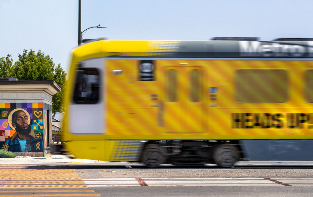 LOS ANGELES, CA -AUGUST 22, 2022:A metro train, traveling on the new K Line, goes past a mural of the late rapper Nipsey Hussle, located on Crenshaw Blvd.at Slauson Ave. in Los Angeles, during a test run. Metros K Line (Crenshaw/LAX Transit Project) will extend light rail from the existing Metro E Line (Expo) at Crenshaw and Exposition Boulevards to the Metro C Line. While the rail line includes 8 new stations, only 7 will be open in the fall of 2022. The train will travel 8.5 miles and will serve the cities of Los Angeles, Inglewood, and El Segundo and portions of unincorporated Los Angeles County. (Mel Melcon / Los Angeles Times via Getty Images)