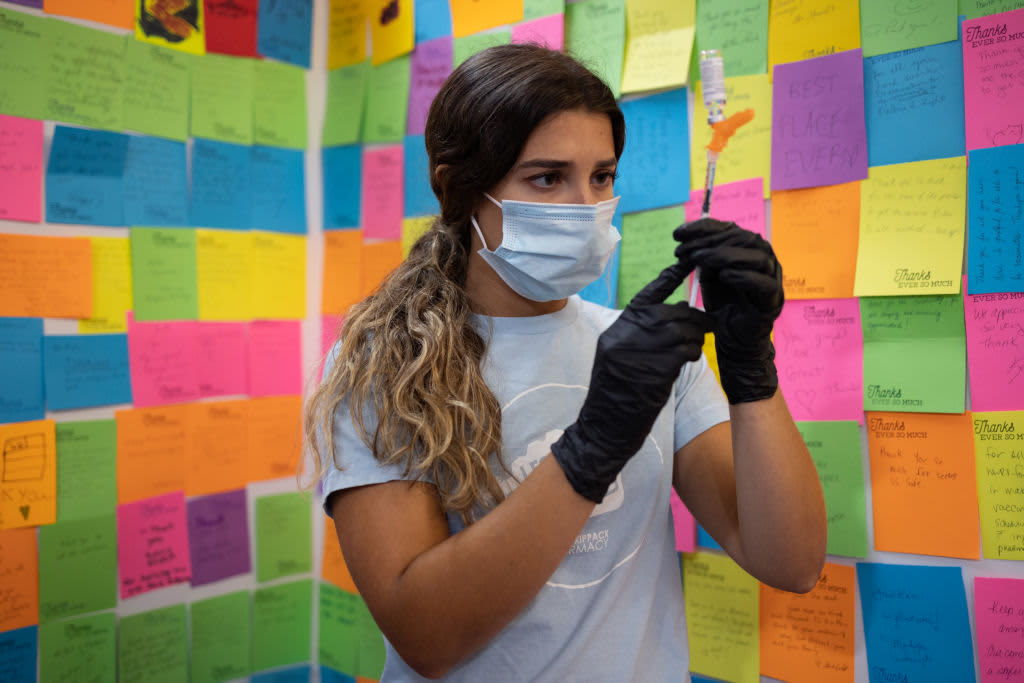 A healthcare worker prepares a dose of a Covid-19 booster vaccine at a pharmacy in Schwenksville, Pennsylvania.