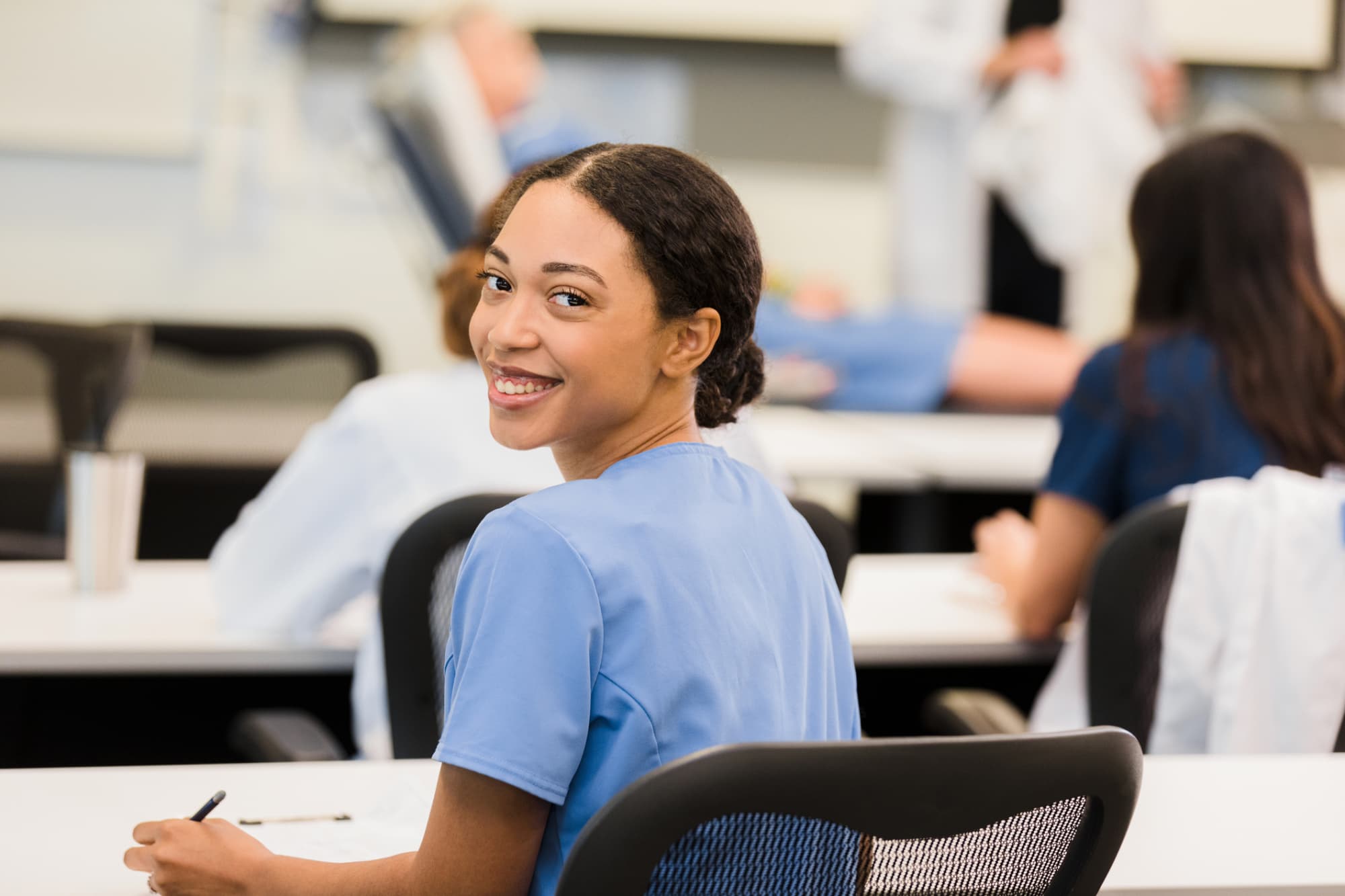 Young adult female medical student looks over shoulder