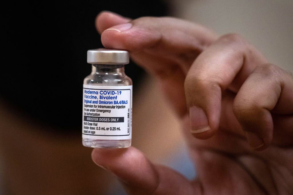 Pharmacist Daniel Carrillo shows a vial of the new COVID-19 booster, which includes protection for the Omicron variant, at the AltaMed Health Services facility in South Gate, California.