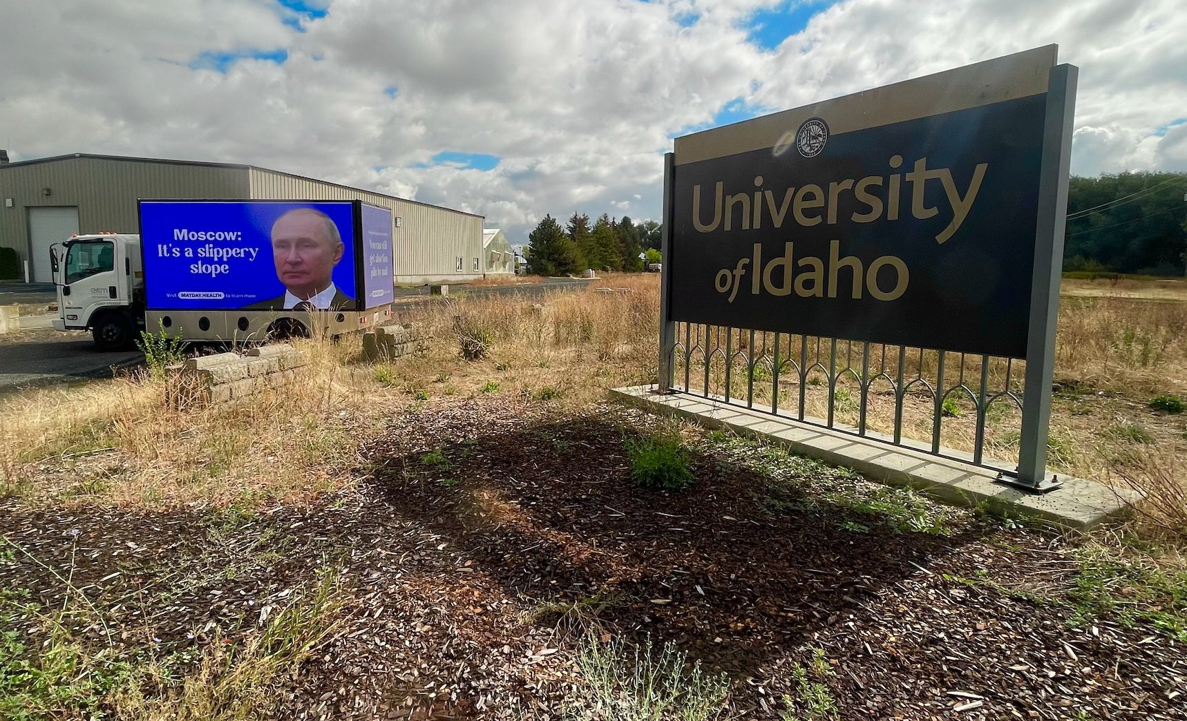 A billboard, created by health-education nonprofit Mayday Health, standing next to the University of Idaho's campus entrance sign in Moscow, Idaho. The billboard shows a picture of Russian President Vladimir Putin with the message, "Moscow: It's a slippery slope," a targeted response to the university's recent abortion and birth control restrictions.