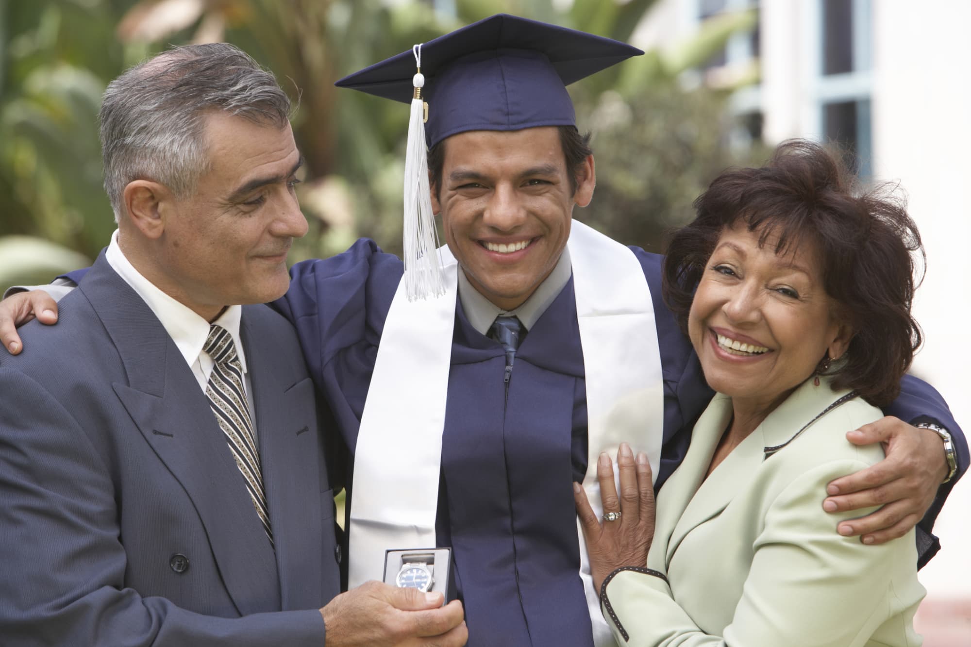 Male student with parents, outdoors, portrait