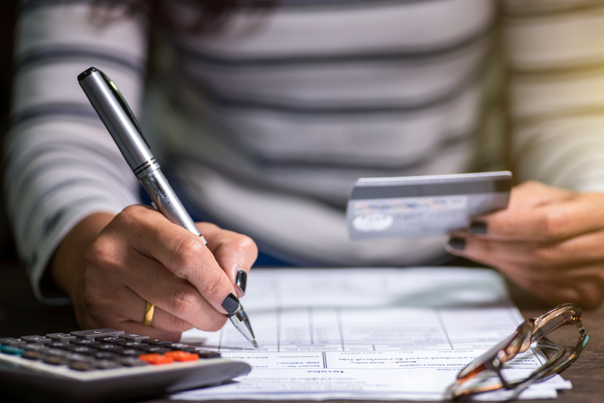 Young woman in her 20s paying uses her credit card to pay her monthly student loan bill.