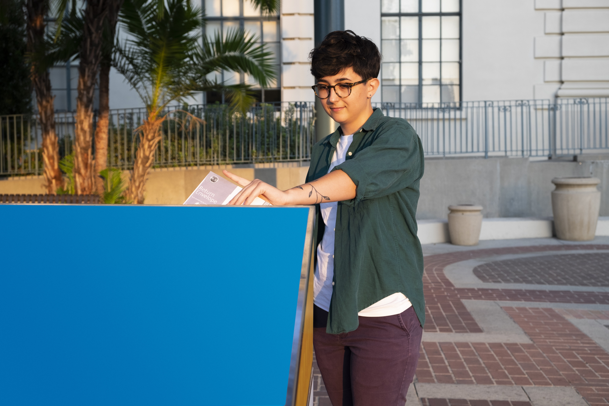 Female college student drops off her absentee ballot into the Official Ballot Drop Box in front of City Hall in Pasadena, California.