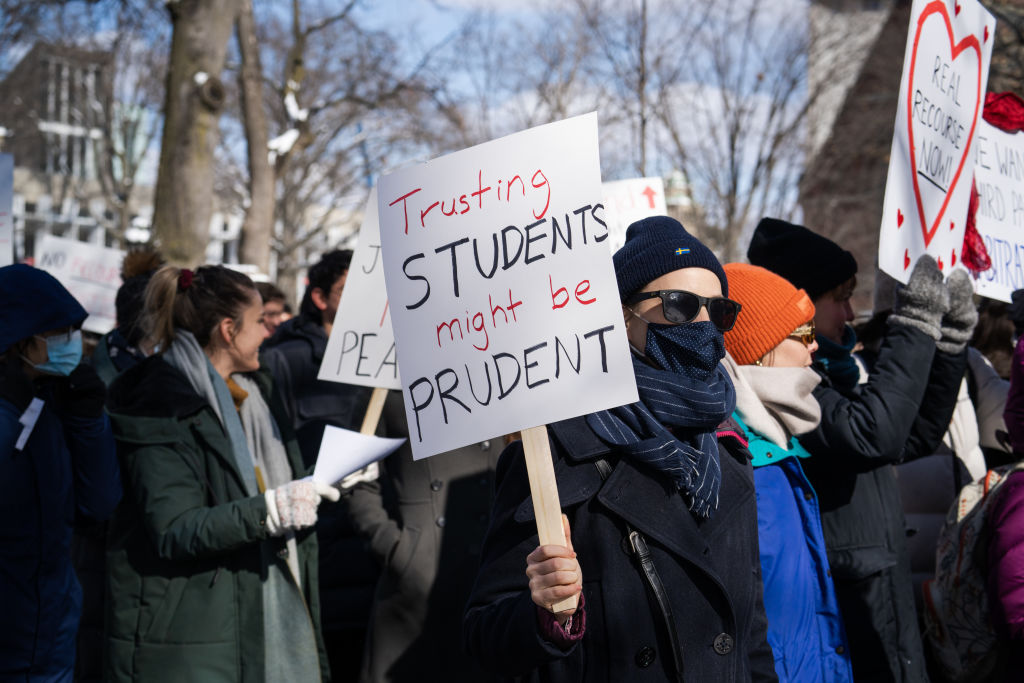 A demonstrator holds a sign during a 'No Justice Walkout' protest at Harvard University in Cambridge, Massachusetts, U.S., on Monday, Feb. 14, 2022. Harvard allowed a star professors sexual abuse of female students to continue unchecked for decades, contributing to a culture of harassment in its Anthropology Department, a new lawsuit alleges. Harvard University disputes the allegations of the lawsuit. Photographer: Vanessa Leroy/Bloomberg via Getty Images