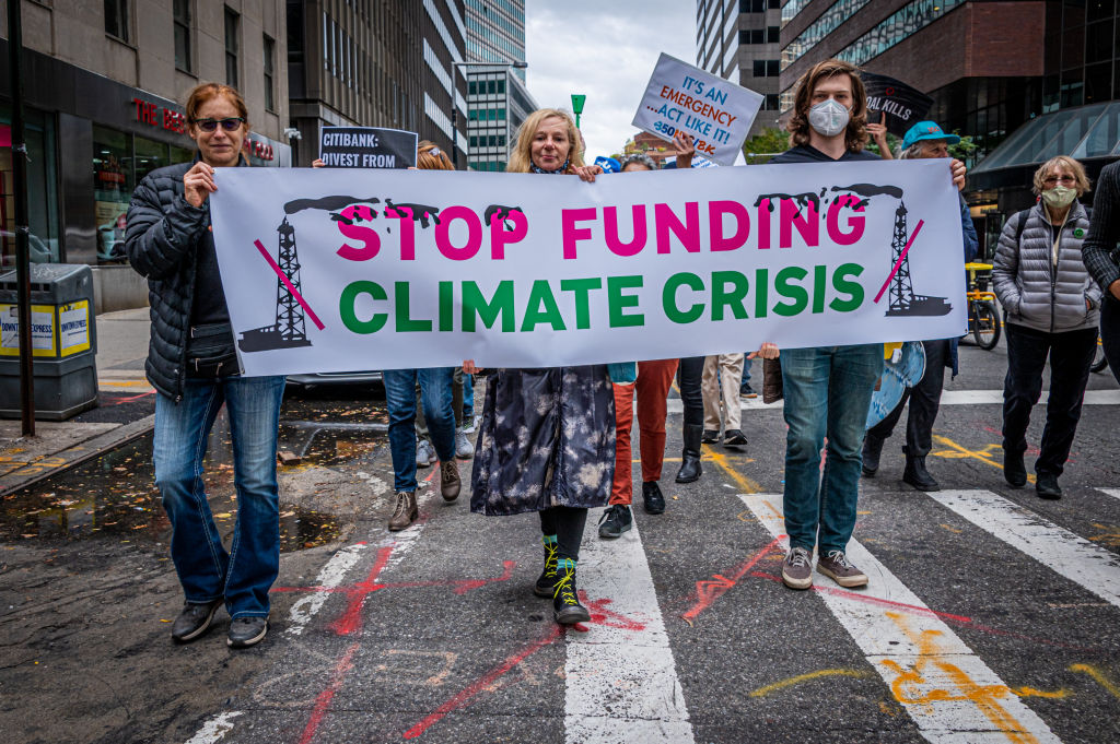 MANHATTAN, NEW YORK, UNITED STATES - 2021/10/29: Participants seen holding a banner at the protest. Hundreds of New Yorkers still reeling from the effects of Hurricane Ida, marched to Citigroup Headquarters and the NY Federal Reserve on to demand two of the citys iconic financial institutions stop the pipeline of money flowing to the fossil fuel industry. The actions were part of a day of international escalation with disruptions targeting financial institutions in 50 cities on six continents to protest the role of the financial sector in fueling the biggest threat to global financial security: climate change. (Photo by Erik McGregor/LightRocket via Getty Images)