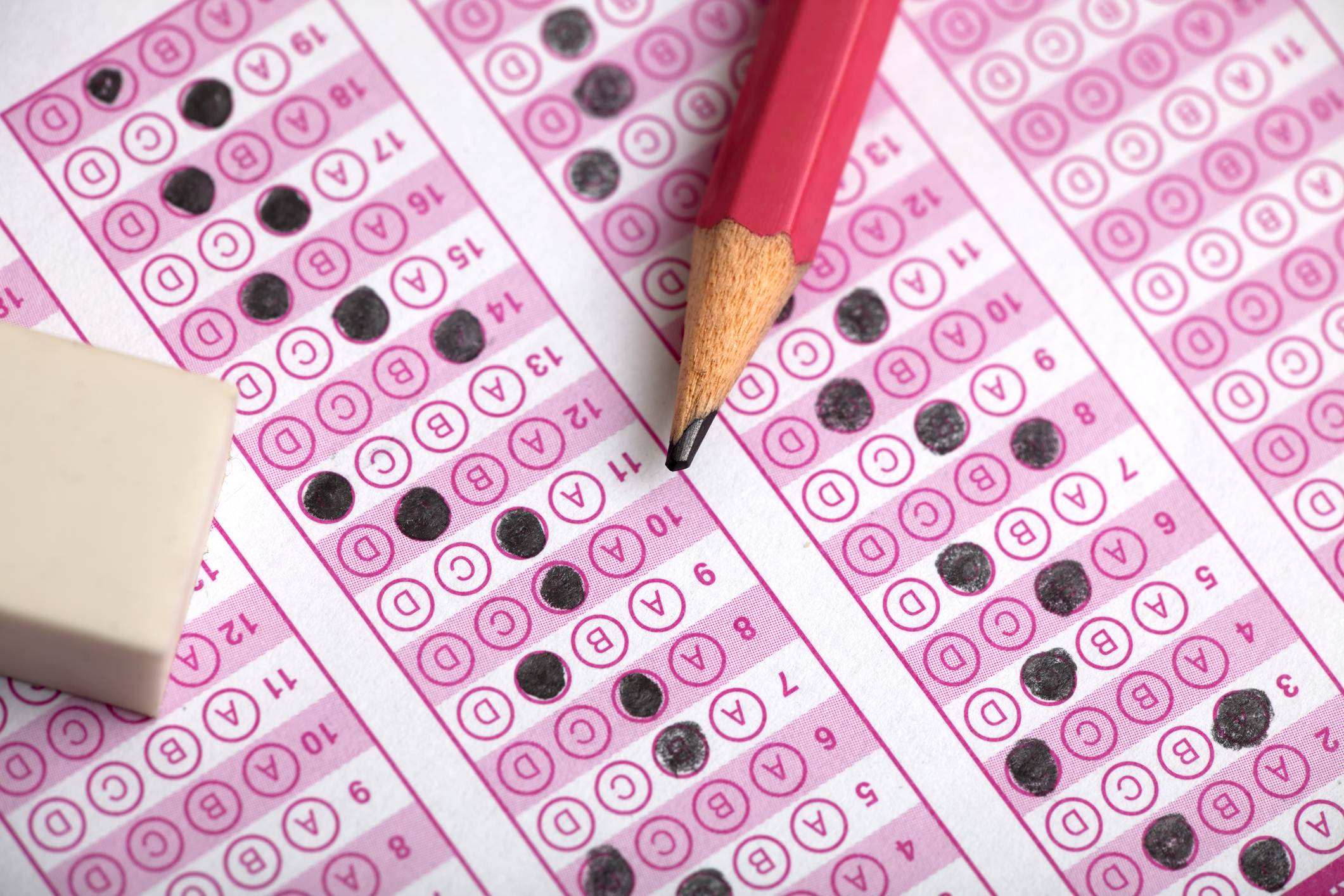 Close up of a student's pencil and eraser on a partially filled out SAT test answer sheet.