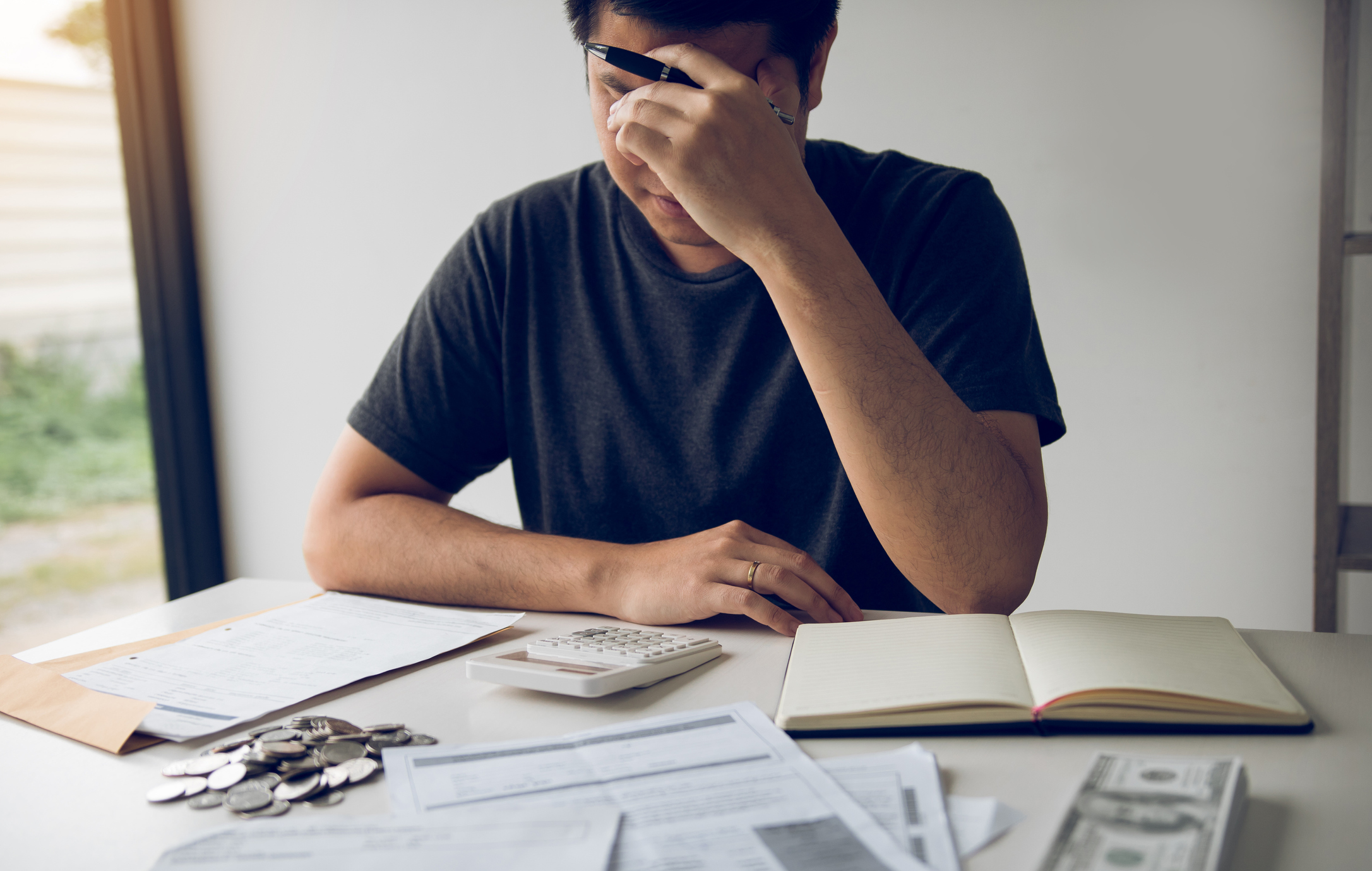 Man With Head In Hands Calculating Bills