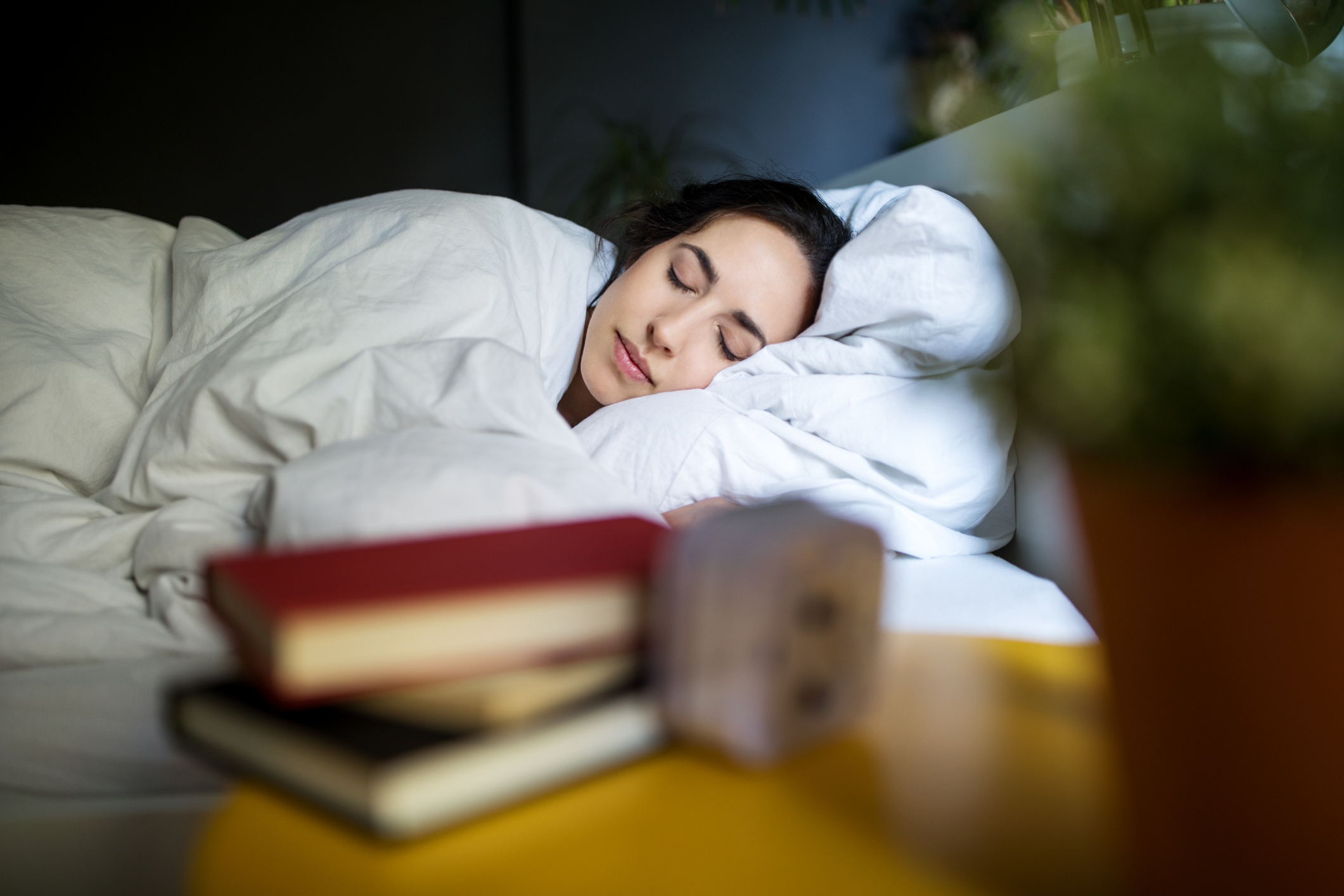 Female college student sleeping peacefully in bed in her apartment.