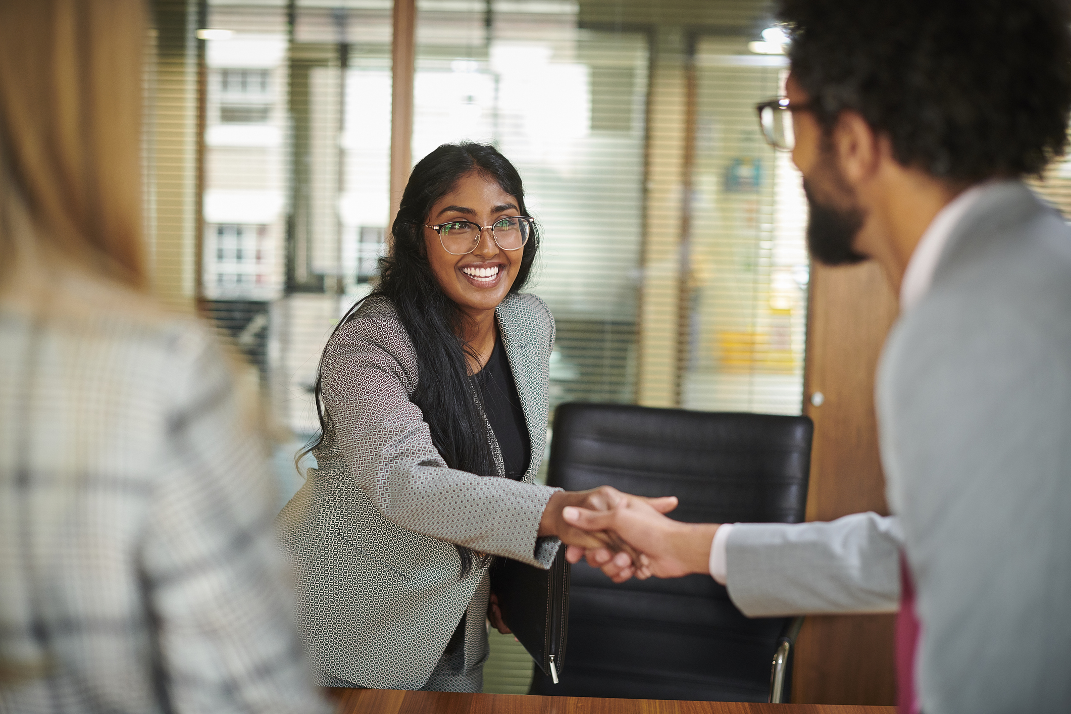 Young business professional shakes hands after a job interview