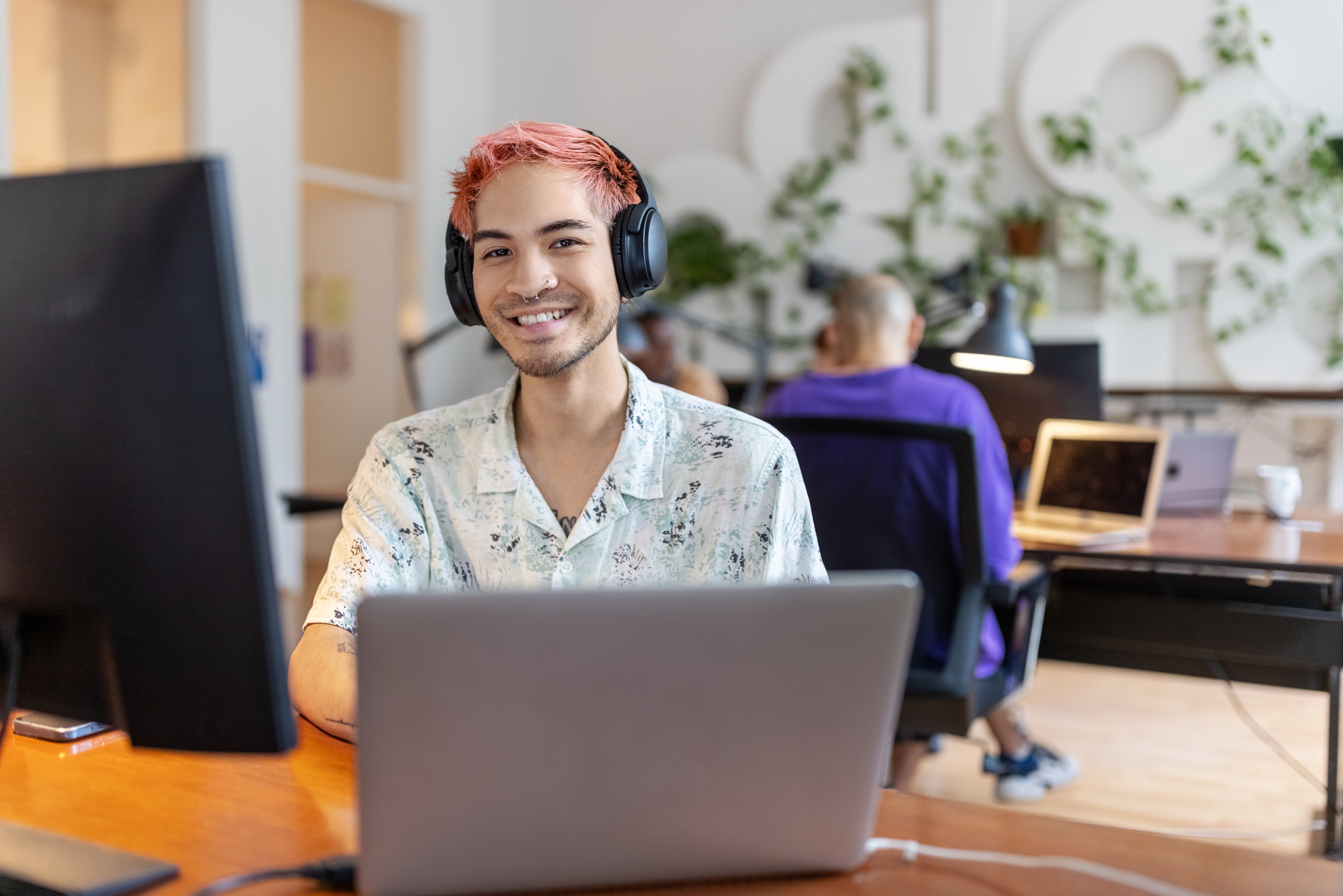 Portrait of Asian man with headphones working at startup office