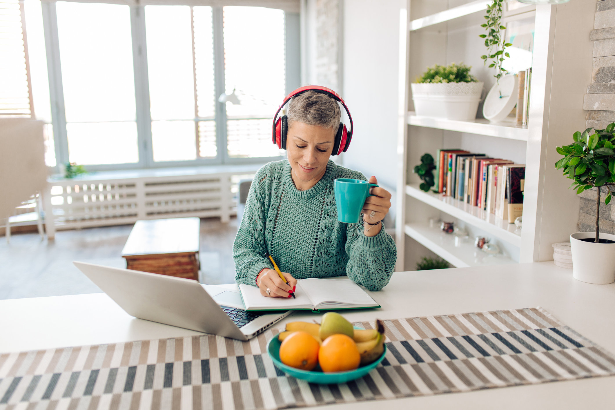 Mid adult woman taking an online college course from her home office.