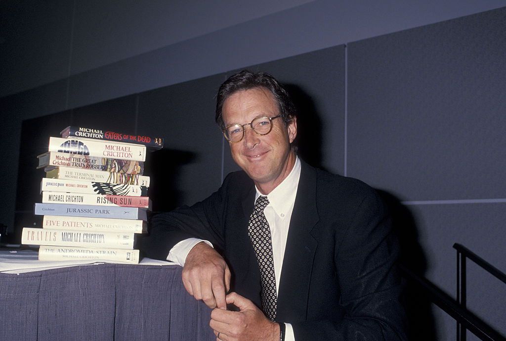 Michael Crichton beside stack of books he wrote