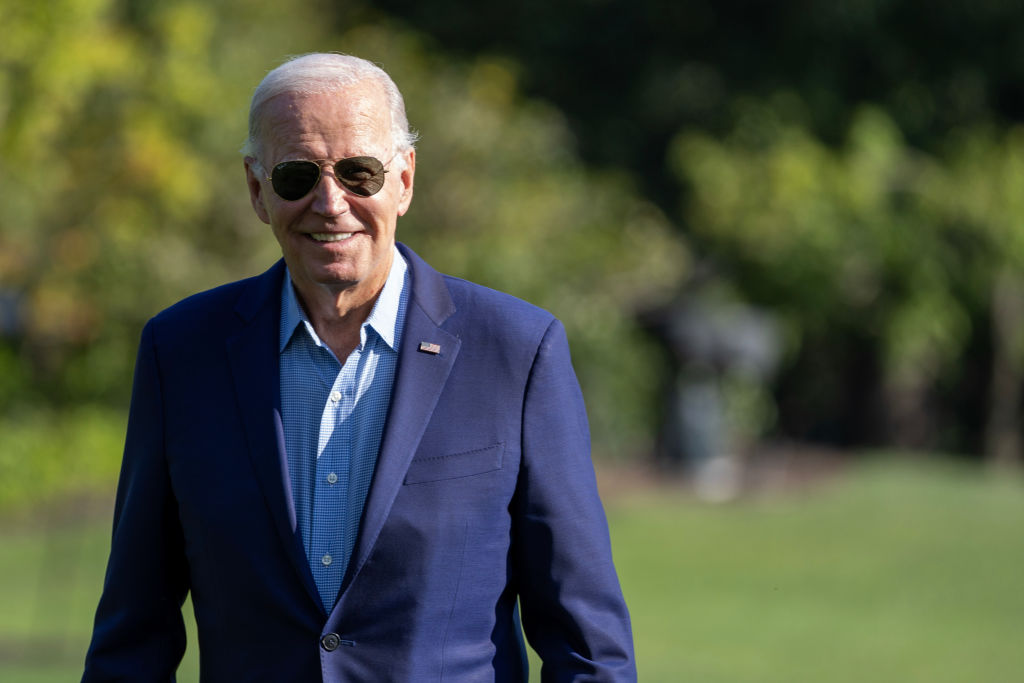 President Joe Biden walking outside and smiling