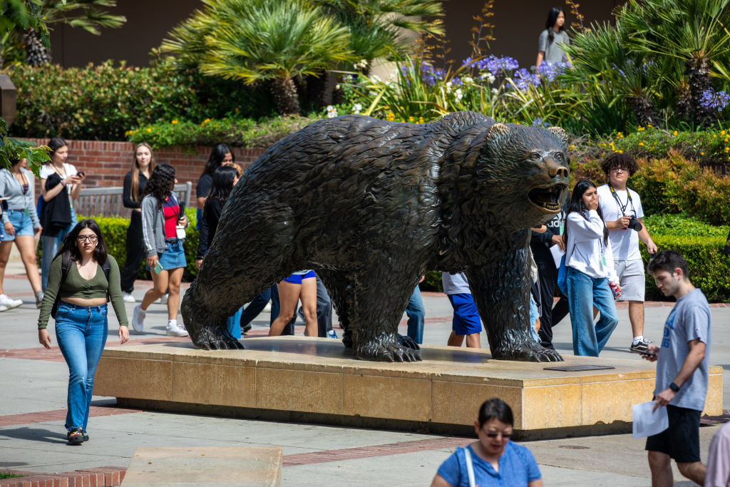 Students walking around bear statue on UCLA campus