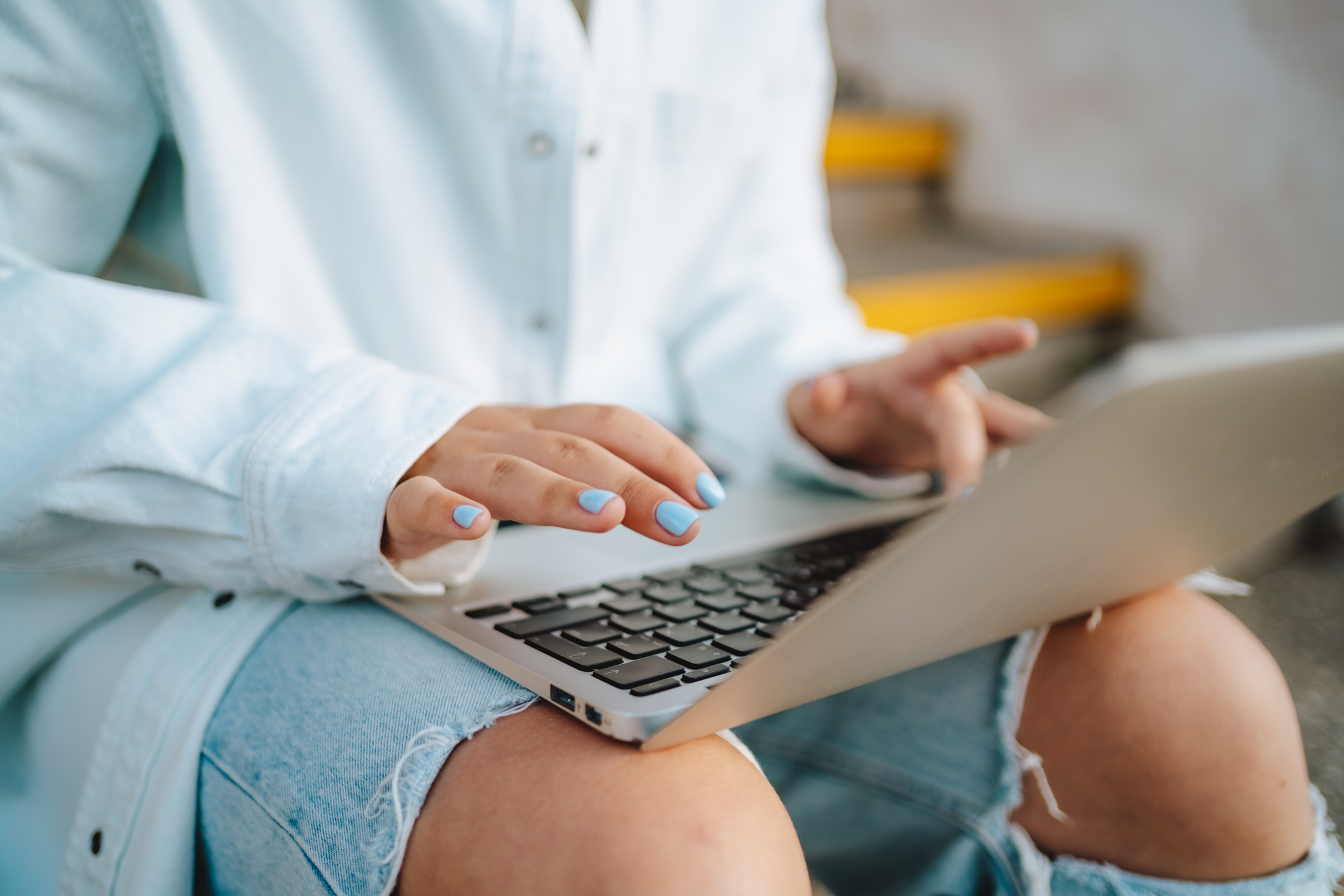 Businesswoman, freelancer working on a laptop on knees, sitting on steps