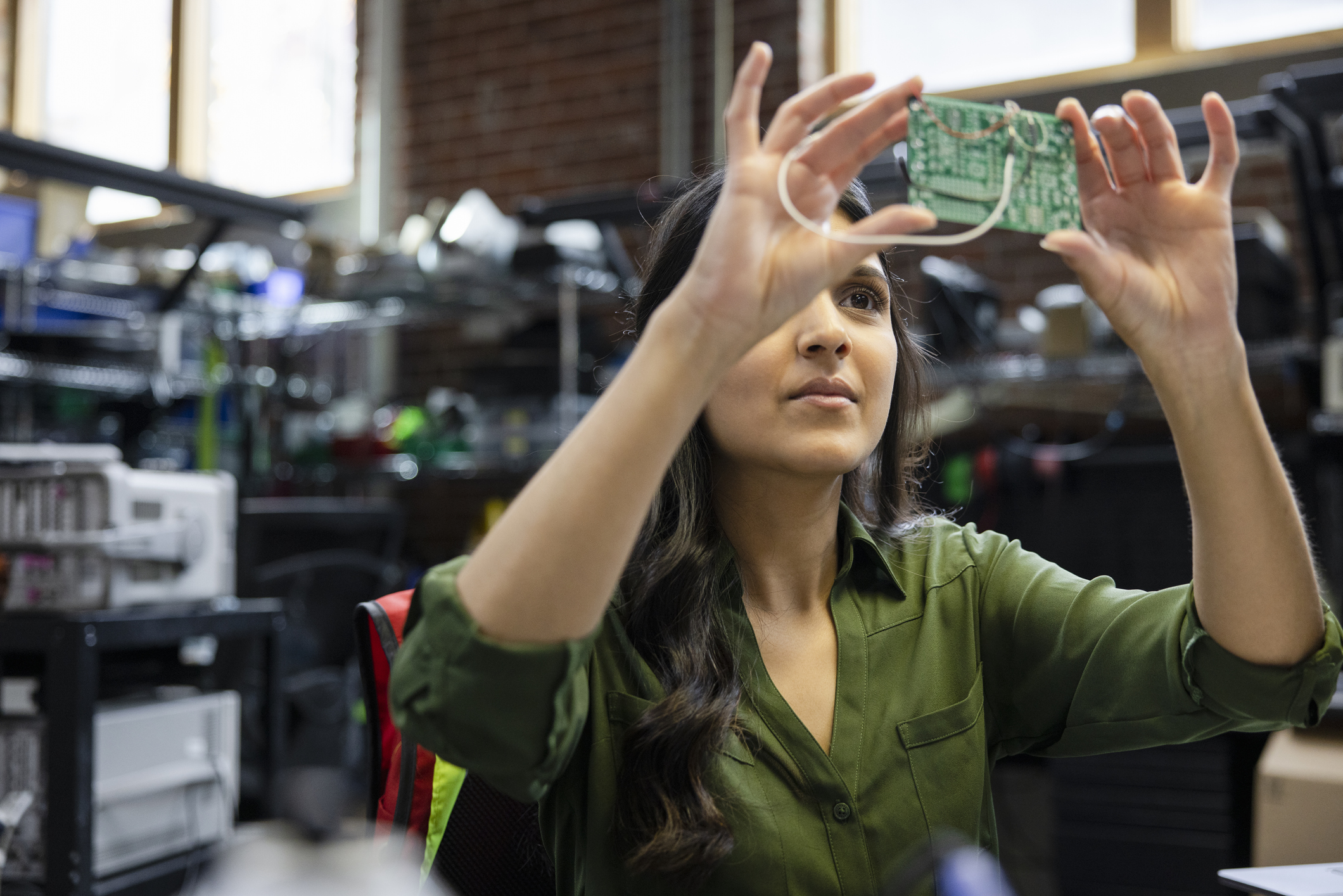 Female engineer inspecting semiconductor in office