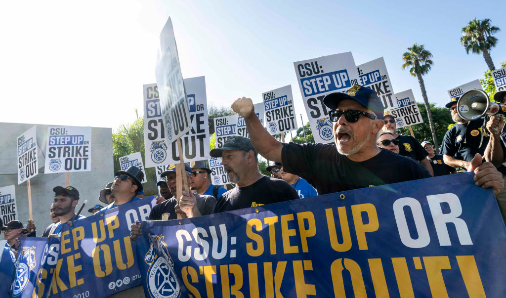 Protestors holding signs that read "CSU: Step Up Or Strike Out"